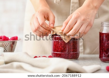 Woman with jar of sweet raspberry jam Royalty-Free Stock Photo #2067188912