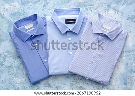 Folded male shirts on light background