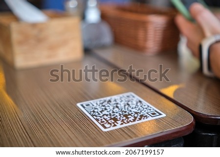 Closeup of guest hand ordering meal in restaurant while scanning qr code with mobile phone for online menu. Royalty-Free Stock Photo #2067199157