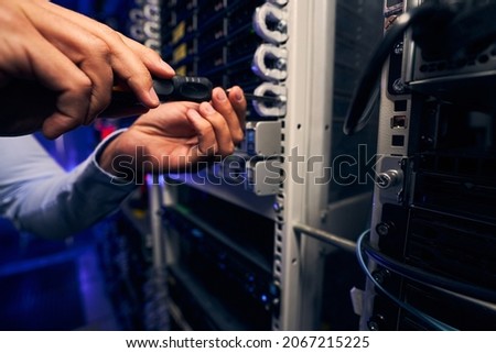 Technician attaching mounted hardware component to front of server rack Royalty-Free Stock Photo #2067215225