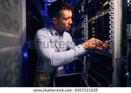 Professional engineer installing equipment in data center Royalty-Free Stock Photo #2067215228