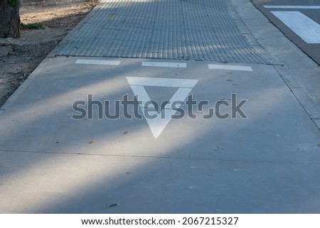 Yield sign on the ground of a bike lane
