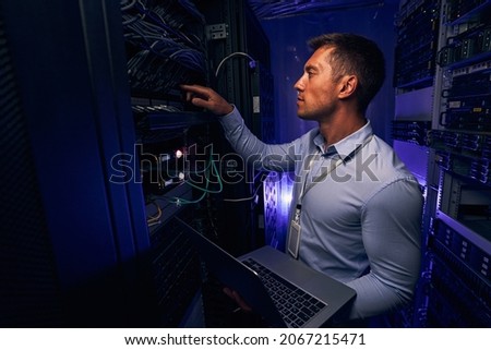 Experienced IT male technician monitoring server performance Royalty-Free Stock Photo #2067215471