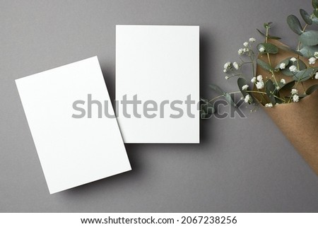 Wedding invitation card mockup with copy space, front and back sides, eucalyptus and gypsophila flowers.