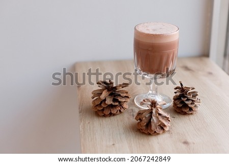 fragrant cocoa in a glass on a light background in winter. free space for text