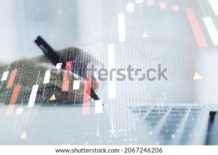 Abstract creative financial graph with world map and with hand writing in notebook on background with laptop, forex and investment concept. Multiexposure