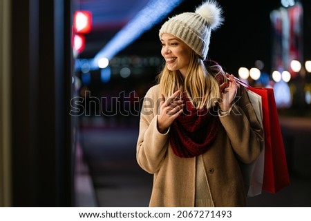 Happy woman hold shopping bags and smiling on city street. Christmas shopping, winter sale concept.