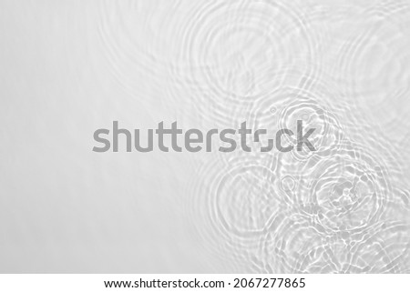 Desaturated transparent clear calm water surface texture with ripples, splashes Abstract nature background. White-grey water waves in sunlight Copy space Cosmetic moisturizer micellar toner emulsion Royalty-Free Stock Photo #2067277865