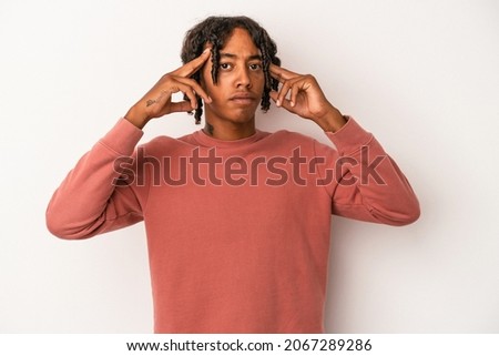 Young african american man isolated on white background focused on a task, keeping forefingers pointing head.
