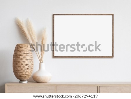 Blank white empty picture frame mockup on white wall. Artwork in interior design. Modern boho style interior with poster template Royalty-Free Stock Photo #2067294119