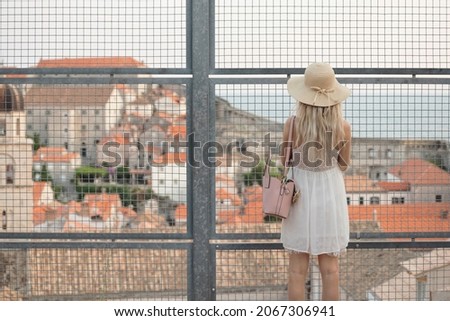 Young traveler girl on basketball court inside the fortress in Dubrovnik, Croatia. Popular tourist destination in Croatia, Dubrovnik tourists take pictures of medieval fortification. Travel to Croatia