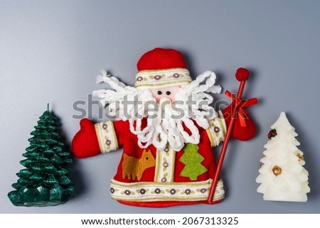 Decorative Santa Claus doll and Christmas tree on a gray background with space to copy. Merry Christmas and Happy New Year