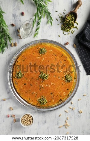Arabic traditional kunafa. desserts  soft konafa in tray sweet with pistachio and pine on top. top view Royalty-Free Stock Photo #2067317528