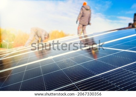 Engineers on the roof of house are checking solar cells in the autumn. Technician worker on solar panels  Royalty-Free Stock Photo #2067330356