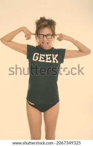 Studio shot of young Chinese nerd woman as geek girl isolated against white background