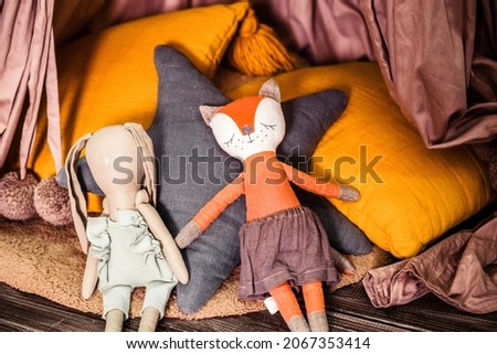 Baby toys sleeping fox and rabbit lie on pillows. Photo