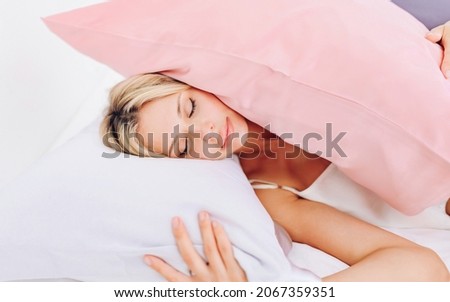 European blonde lying on a bed with pillows, a silk pillowcase.
 Royalty-Free Stock Photo #2067359351