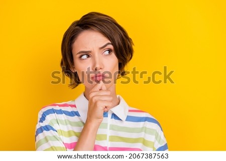 Photo of unsure millennial brunette lady look empty space wear sriped t-shirt isolated on yellow color background Royalty-Free Stock Photo #2067387563