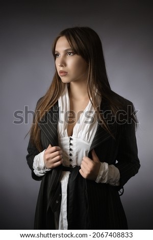 beautiful portrait of a girl in a jacket. office style. Gray background