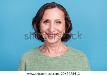 Portrait of attractive cheerful content grey-haired middle-aged woman wearing pullover isolated over vivid blue color background