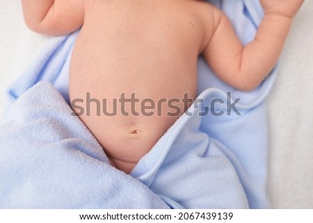 The baby's navel in the diaper. Healthy stomach, a cure for gas in newborns. Intestinal colic. Closeup of newborn baby's navel. Navel after healing. One weeks old baby. Happy Family concept. Royalty-Free Stock Photo #2067439139