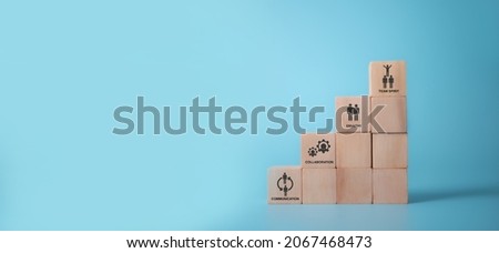 Soft skills training and improvement concept. Human resource management.  Wooden cube staircases with the soft skills symbols; communication, collaboration, empathy and  team spirit on blue background Royalty-Free Stock Photo #2067468473