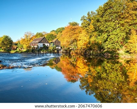 Half-timbered houses on the river bank. View on the Wipperkotten on the Wupper river. Beautiful golden autumn in Solingen in the Bergisches Land. Landscape photography Royalty-Free Stock Photo #2067470606