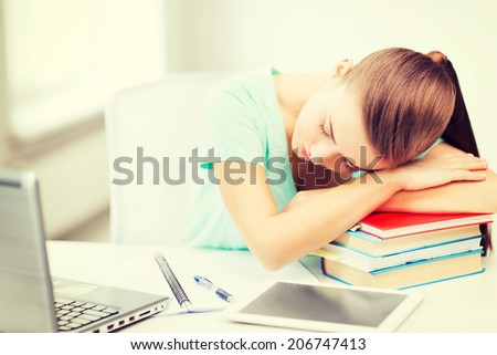 education and technology concept - tired student sleeping on stack of books