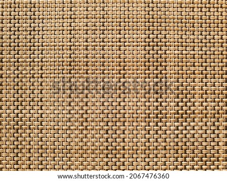 Pattern of wooden twigs constricted together. Wood weaves together forming a mat. Texture of wooden twigs weaved into a structure. Crossing structure of wood.  Royalty-Free Stock Photo #2067476360