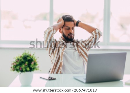 business man is frustrated on a table with a laptop Royalty-Free Stock Photo #2067491819