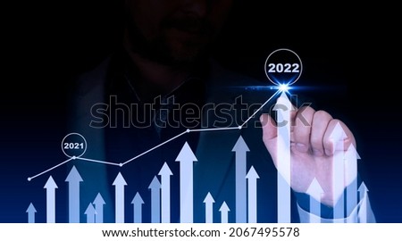 Businessman points to a graph with an arrow, corporate plan for future growth. Business development and success and growing growth. 2021-2022 Concept. High quality photo