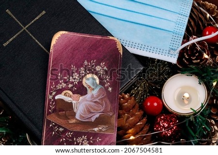 Advent wreath, bible and surgical mask. Christmas composition. France.   01-6-2021
