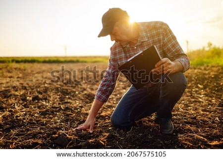Male hands touching soil on the field. Expert hand of farmer checking soil health before growth a seed of vegetable or plant seedling. Business or ecology concept. Royalty-Free Stock Photo #2067575105