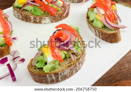 Brown bread with avocado, smoked salmon, boiled egg, onion