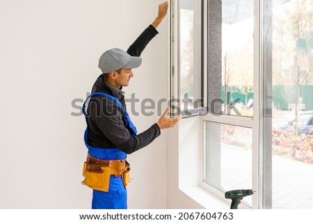 Construction Worker Installing New Windows In House Royalty-Free Stock Photo #2067604763