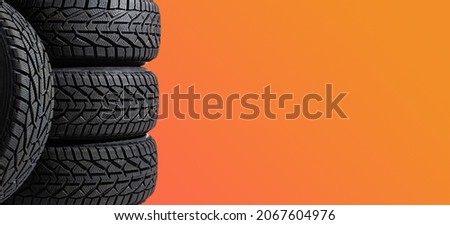 Winter car tires. Group of tires for winter driving on a yellow background.