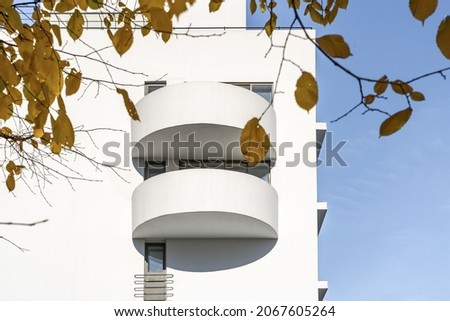 The facade of a white minimalist house with semicircular balconies. Architecture in autumn.  Detailed pictures of exterior urban architecture. Element of architecture.