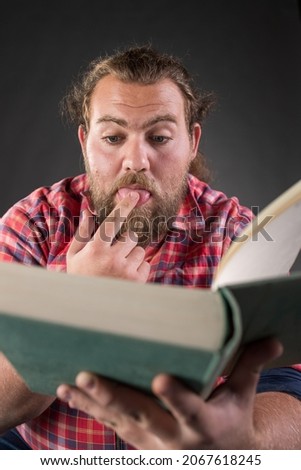 Funny man reading book, very interested in subject