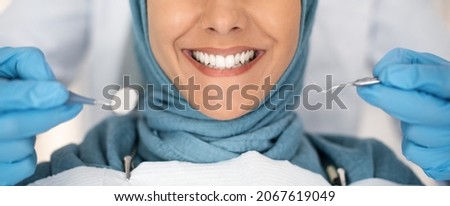 Dental Check Up. Closeup Shot Of Smiling Muslim Lady Getting Treatment In Stomatologic Clinic, Dentist In Blue Gloves Examining Teeth Of Islamic Lady In Hijab, Using Sterile Dental Tools, Cropped Royalty-Free Stock Photo #2067619049