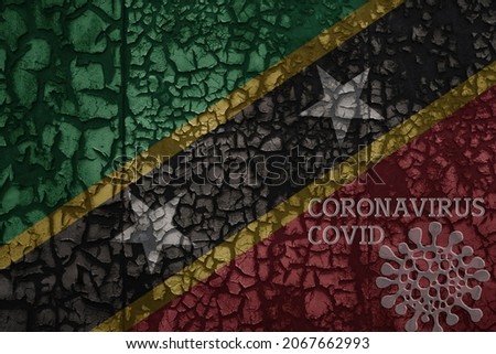 flag of saint kitts and nevis on a old vintage metal rusty cracked wall with text coronavirus, covid, and virus picture.