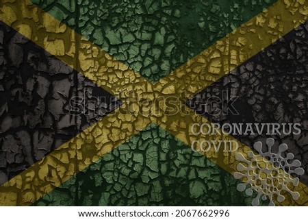 flag of jamaica on a old vintage metal rusty cracked wall with text coronavirus, covid, and virus picture.