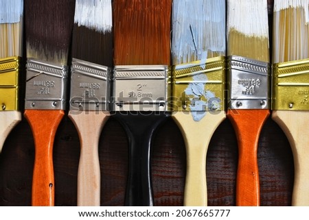 A top view image of several types of old used paint brushes used in home renovations.  Royalty-Free Stock Photo #2067665777