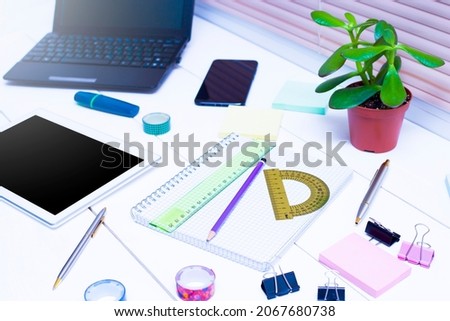 Technologies - laptop, tablet, phone and stationery on a white table.