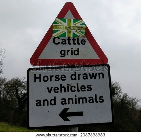 Cattle grid warning sign with union flag sticker edited to display rude slogan