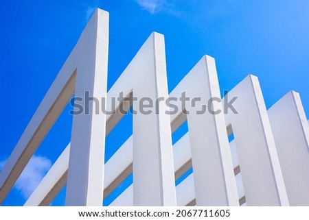 Concrete columns and abstract architecture contrast with the blue sky. Beautiful and clear light. Modern architecture and building concepts.