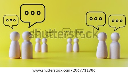 Mingle, discussion, chatting concept. Wooden dolls with speech bubble on yellow background Royalty-Free Stock Photo #2067711986