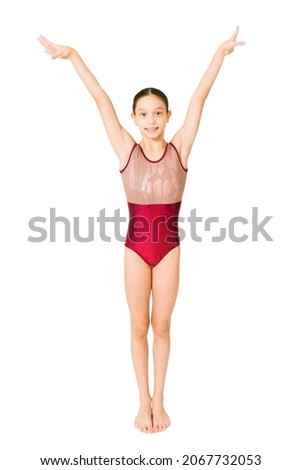Beautiful young girl finishing her artistic gymnastics routine and smiling isolated on a white background