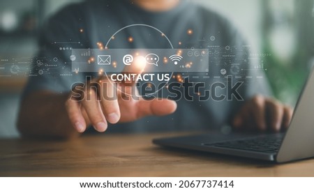 Contact us or Customer support hotline people connect. Businessman using a laptop and touching on virtual screen contact icons ( email, address, live chat, internet wifi ). Royalty-Free Stock Photo #2067737414