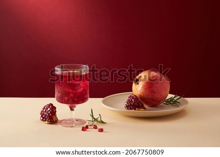 Pomegranate juice in a white dish with pomegranate seed with red background , for food adverting , front view 