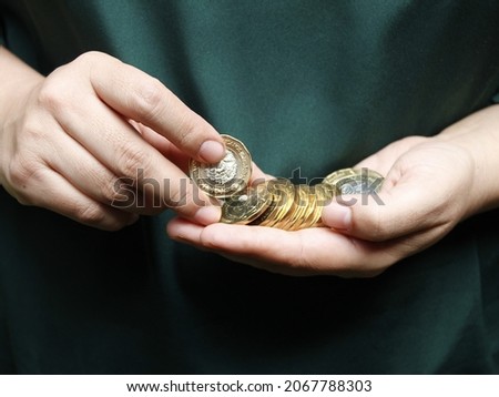 hands of a woman counting mexican coins of twenty pesos Royalty-Free Stock Photo #2067788303